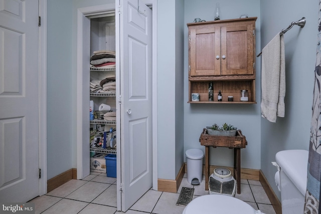 bathroom featuring tile patterned flooring, baseboards, and a closet