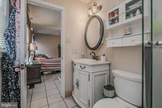 ensuite bathroom featuring toilet, connected bathroom, vanity, and tile patterned floors