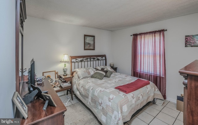 bedroom with light tile patterned flooring and a textured ceiling