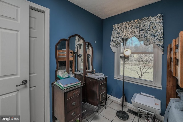 home office featuring baseboards, a textured ceiling, and light tile patterned flooring