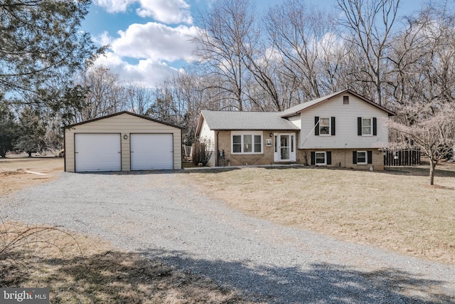 tri-level home featuring brick siding, a detached garage, and an outdoor structure