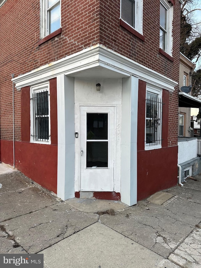 property entrance featuring brick siding