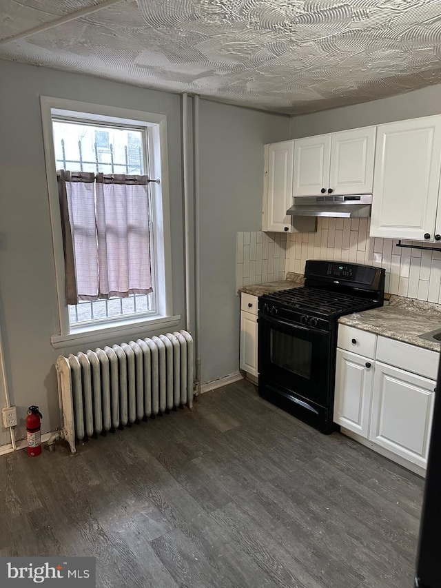 kitchen with under cabinet range hood, white cabinetry, black gas range oven, and radiator heating unit