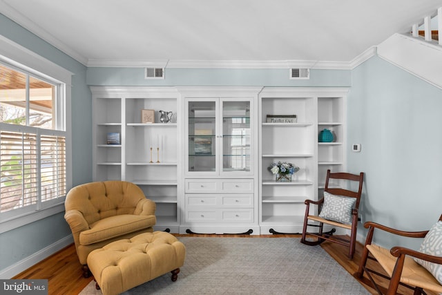 sitting room featuring ornamental molding, visible vents, baseboards, and wood finished floors