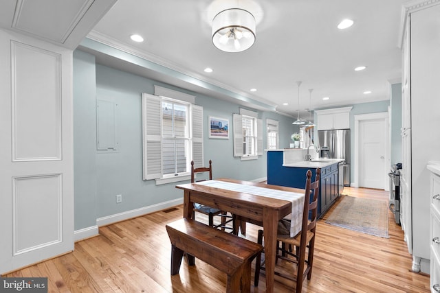 dining area featuring light wood-type flooring, crown molding, baseboards, and recessed lighting