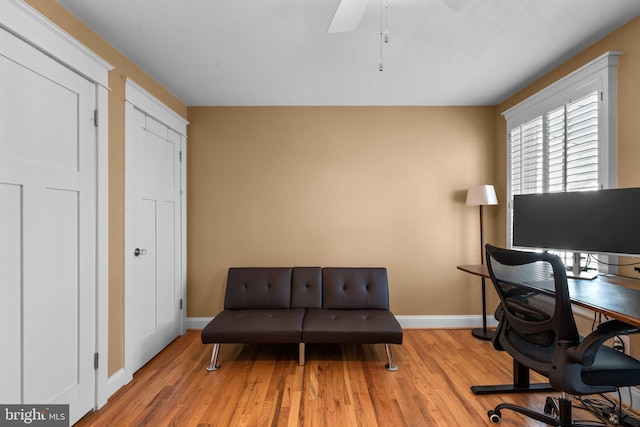 office space with wood finished floors, a ceiling fan, and baseboards