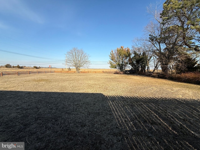 view of yard featuring fence and a rural view