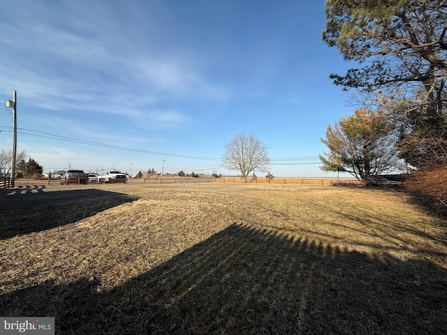 view of yard with a rural view and fence