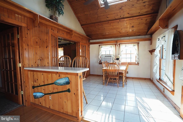 dining room with lofted ceiling, light tile patterned flooring, wooden ceiling, and baseboards