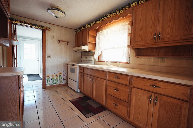 kitchen featuring open shelves, electric range, brown cabinetry, a sink, and under cabinet range hood