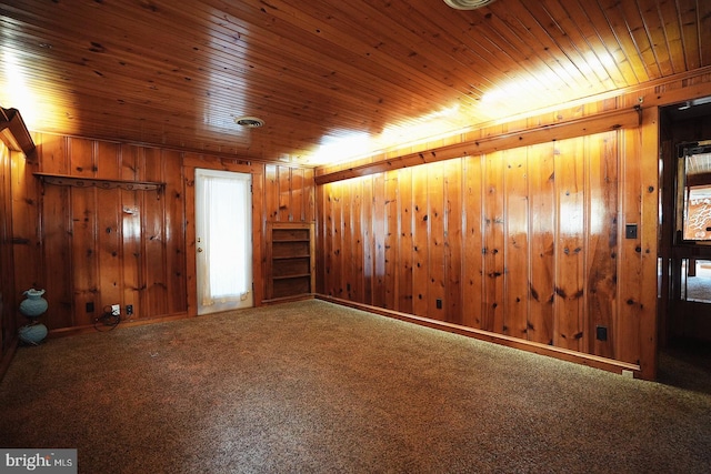 interior space featuring carpet floors, wood ceiling, and wood walls