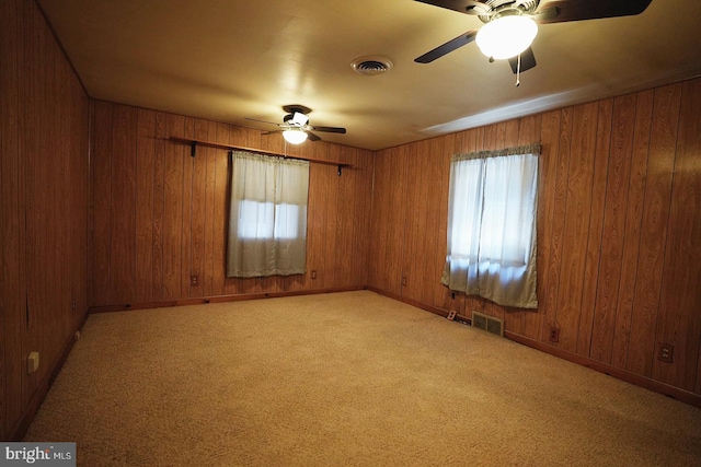 unfurnished room featuring light carpet, visible vents, and a wealth of natural light