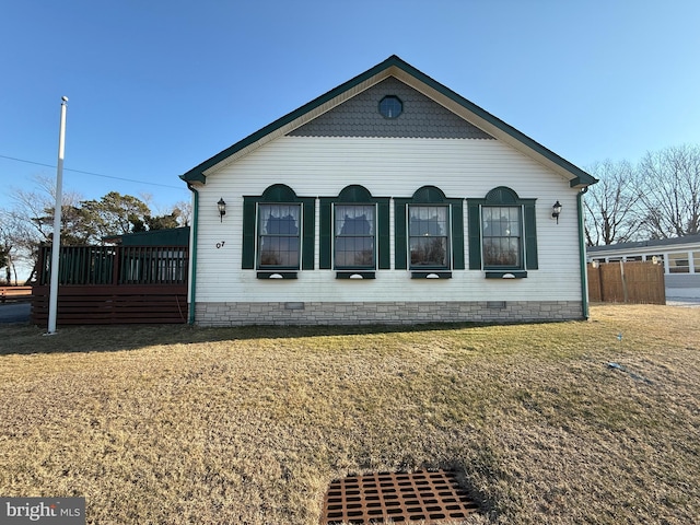 view of side of home with crawl space and a lawn