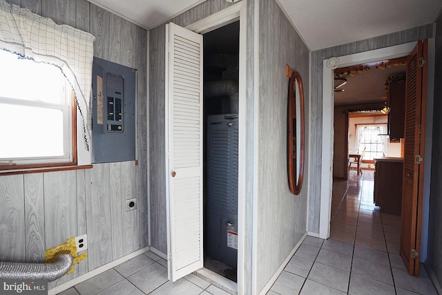 corridor with light tile patterned floors, electric panel, wallpapered walls, and a wainscoted wall