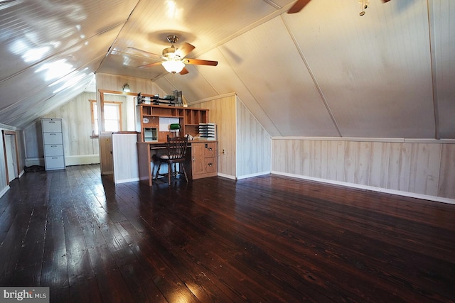 bonus room featuring dark wood-type flooring, lofted ceiling, ceiling fan, and baseboards