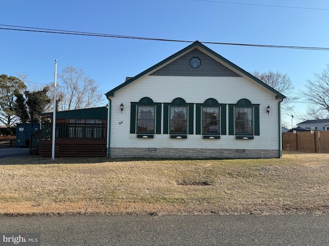 view of front facade with a front yard, crawl space, and fence