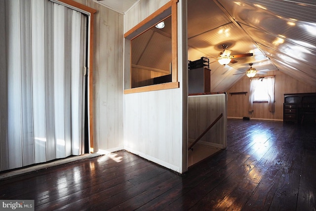 bonus room featuring vaulted ceiling, wood walls, and dark wood-style flooring