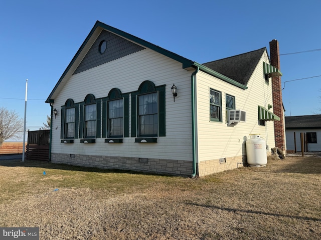 view of side of property featuring a shingled roof, cooling unit, crawl space, and a yard