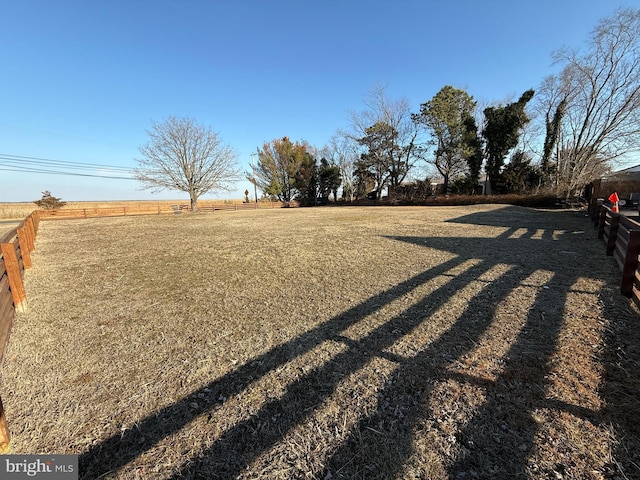 view of yard featuring a rural view and fence