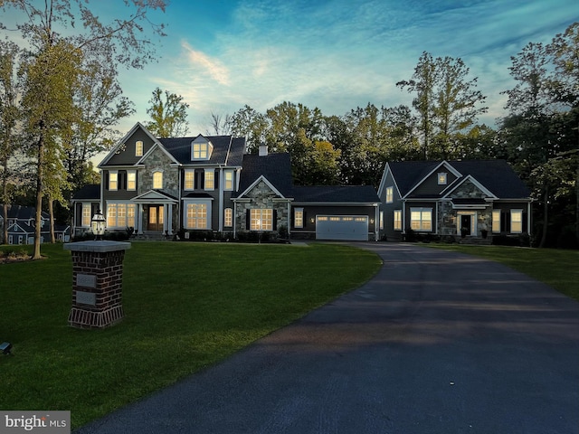 view of front of property featuring a garage, stone siding, aphalt driveway, and a front lawn