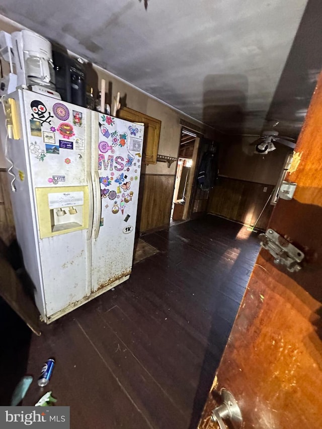 kitchen featuring brown cabinetry, white refrigerator with ice dispenser, and dark wood finished floors