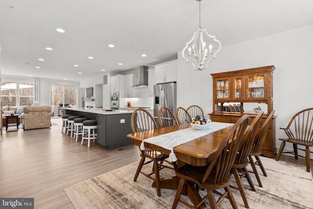 dining room featuring recessed lighting, light wood finished floors, and a chandelier