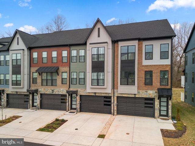 townhome / multi-family property featuring a garage, stone siding, driveway, and a shingled roof