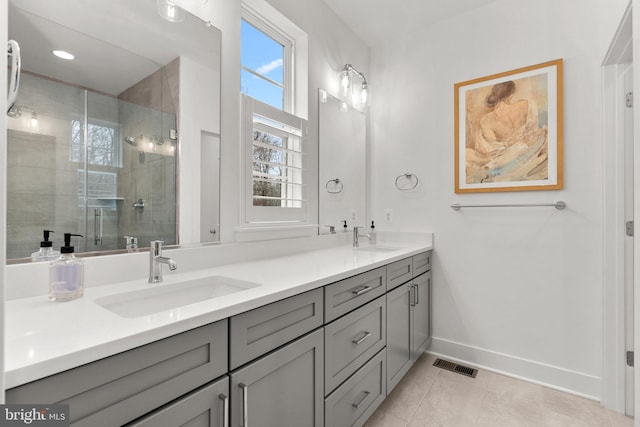 bathroom with double vanity, visible vents, a stall shower, and a sink