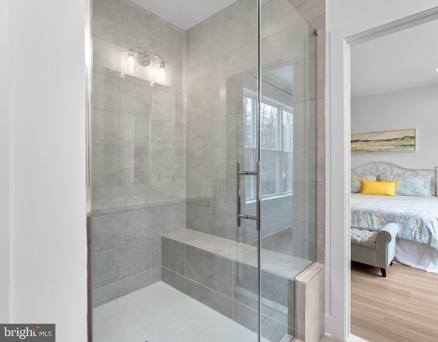 bathroom featuring wood finished floors, ensuite bath, and a shower stall