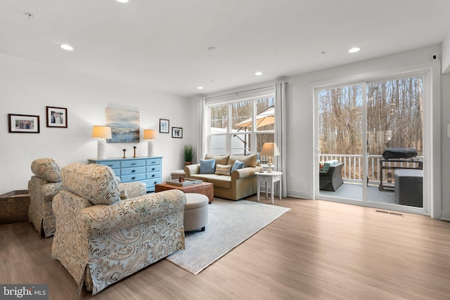 living area featuring recessed lighting, wood finished floors, and visible vents