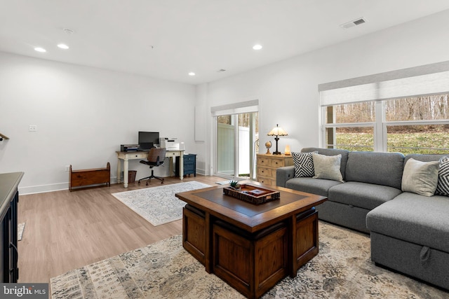 living room with recessed lighting, light wood-type flooring, baseboards, and visible vents