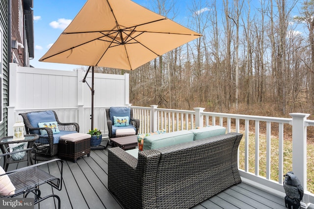 deck featuring outdoor lounge area and fence