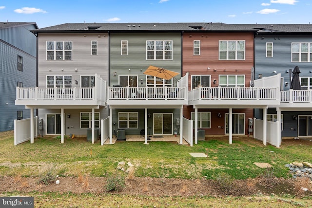 back of property with a yard and central AC unit