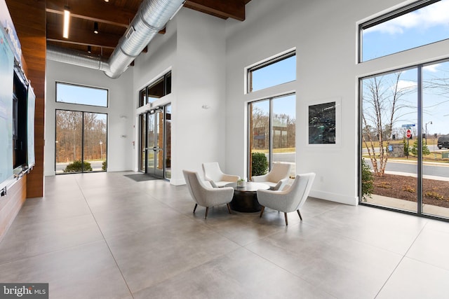 dining area featuring a high ceiling, a healthy amount of sunlight, and concrete floors