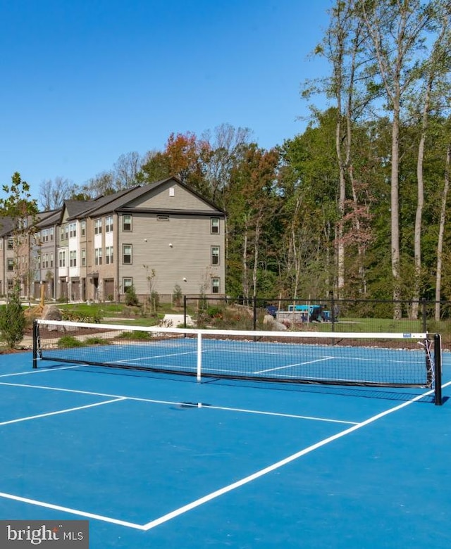 view of sport court featuring a residential view and fence