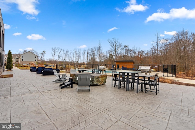 view of patio / terrace featuring outdoor dining space, fence, a fenced in pool, and a grill