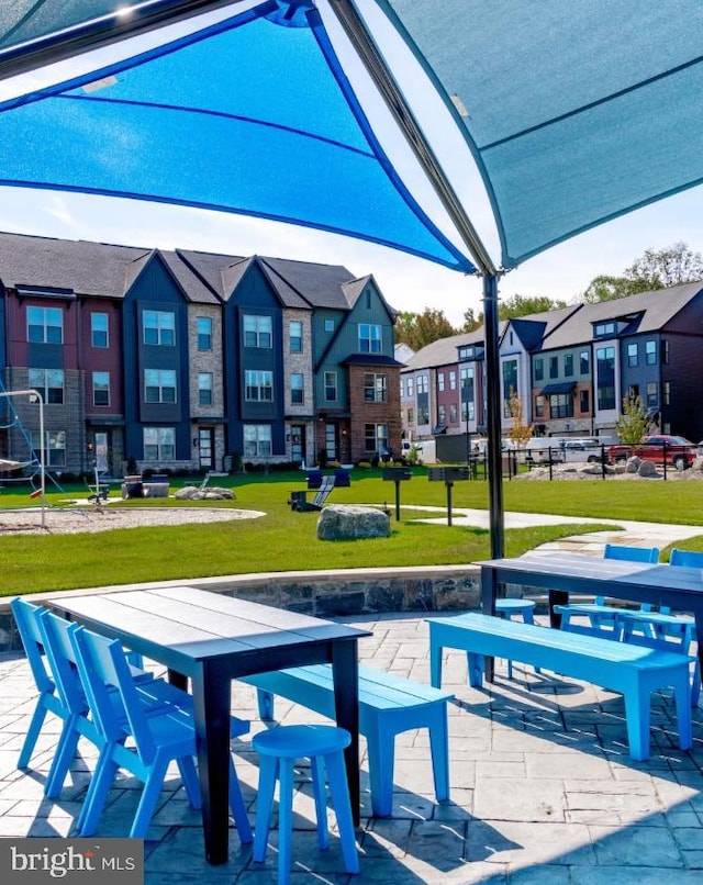 view of community with a residential view, a lawn, and a patio