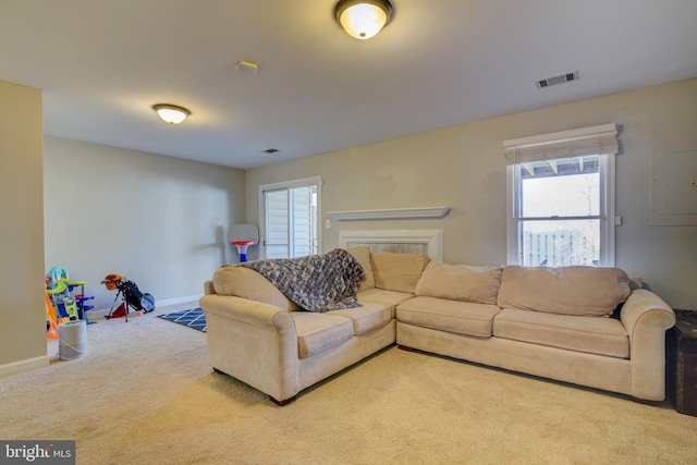 carpeted living area featuring visible vents and baseboards