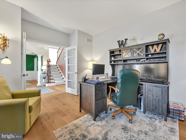 home office with visible vents, wood finished floors, and french doors