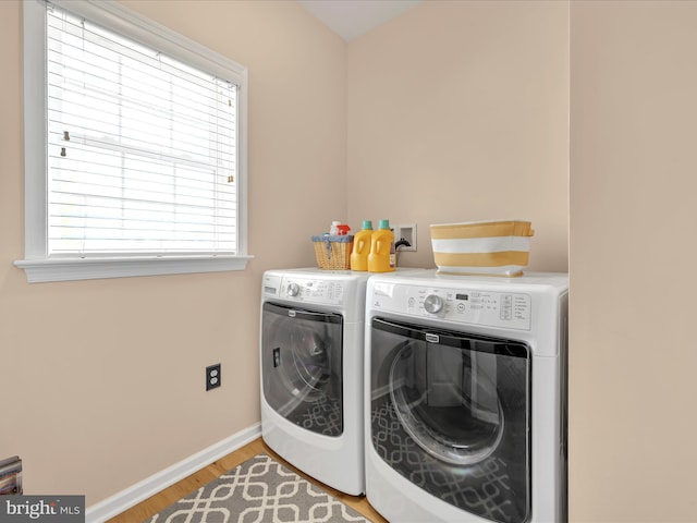 washroom with laundry area, light wood-style flooring, baseboards, and separate washer and dryer