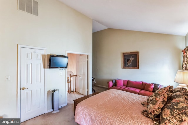 carpeted bedroom featuring lofted ceiling and visible vents