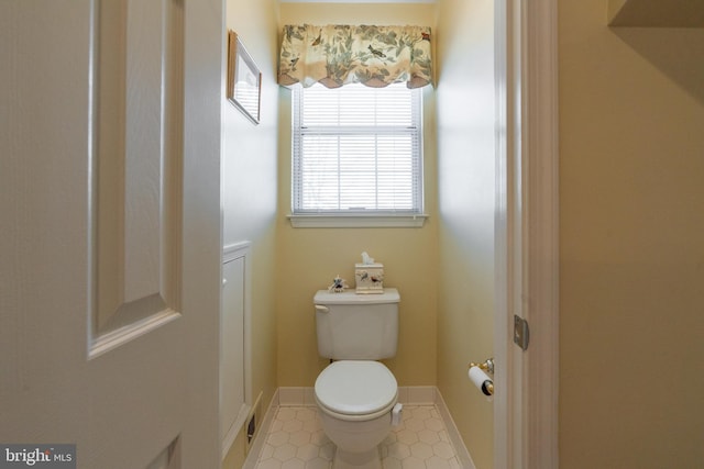 bathroom with baseboards and toilet