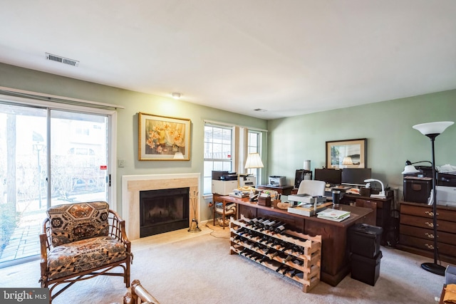 office area with visible vents, carpet flooring, and a high end fireplace