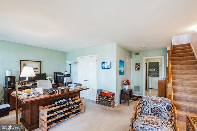 home office featuring light carpet, washing machine and dryer, visible vents, and baseboards