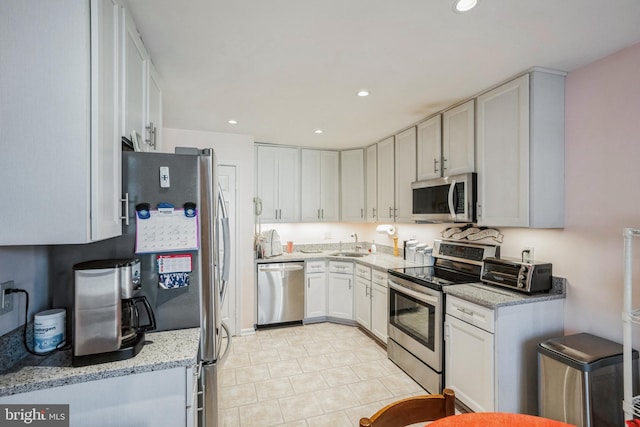 kitchen with a toaster, recessed lighting, appliances with stainless steel finishes, white cabinetry, and a sink