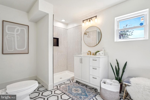 bathroom with baseboards, toilet, a stall shower, and vanity