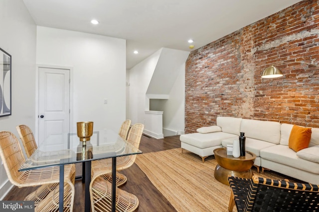 dining space featuring recessed lighting, baseboards, wood finished floors, and brick wall