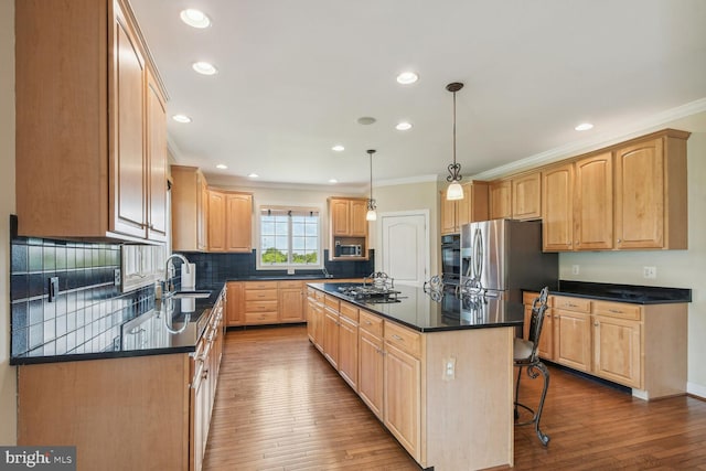 kitchen featuring dark countertops, a kitchen island, stainless steel fridge with ice dispenser, and decorative light fixtures