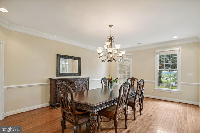 dining room with light wood-style floors, a notable chandelier, ornamental molding, and baseboards