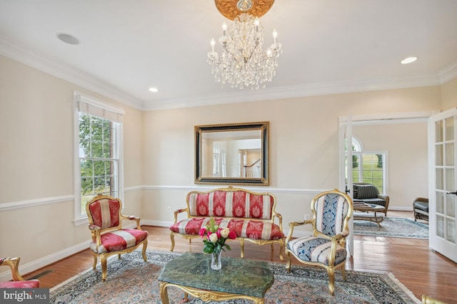 living area featuring crown molding, plenty of natural light, baseboards, and wood finished floors